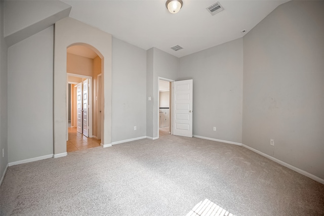 unfurnished bedroom featuring light colored carpet and lofted ceiling