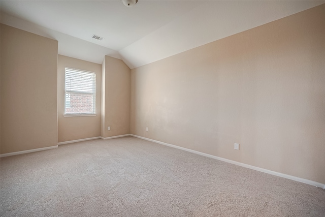 empty room featuring light carpet and vaulted ceiling