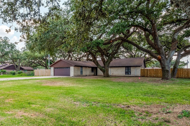 ranch-style home featuring a garage and a front lawn