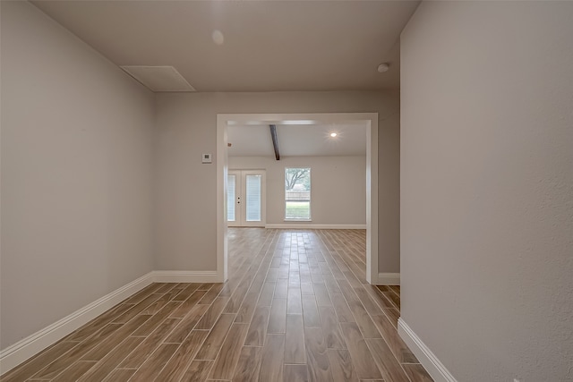 hallway featuring beam ceiling and hardwood / wood-style floors