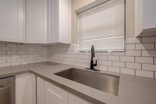 kitchen featuring white cabinetry, light stone countertops, sink, and tasteful backsplash