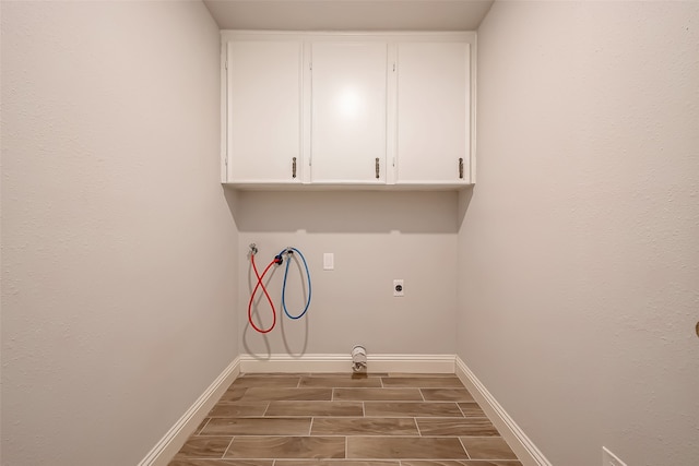 laundry room with electric dryer hookup, washer hookup, and cabinets