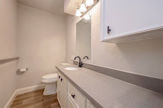 bathroom featuring wood-type flooring, vanity, and toilet