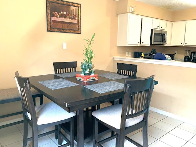 tiled dining area with a textured ceiling