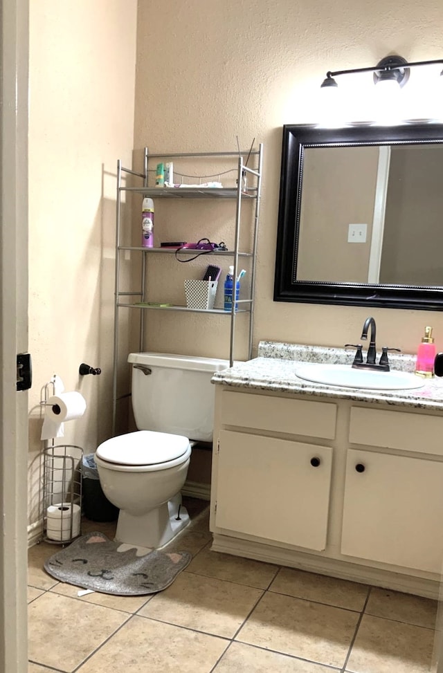 bathroom with vanity, toilet, and tile patterned floors