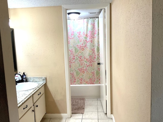 bathroom with vanity, shower / bathtub combination with curtain, and tile patterned floors