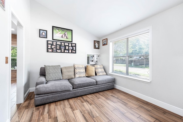 living room featuring lofted ceiling and light hardwood / wood-style floors