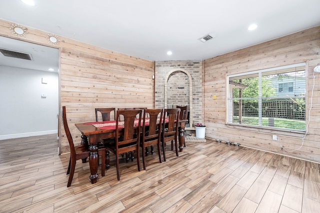 dining space featuring wood walls and light hardwood / wood-style floors