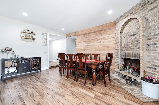 dining room with light hardwood / wood-style floors and a fireplace