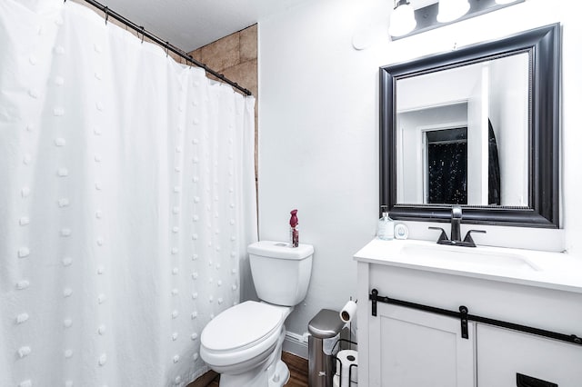 bathroom featuring vanity, toilet, a textured ceiling, hardwood / wood-style floors, and a shower with shower curtain