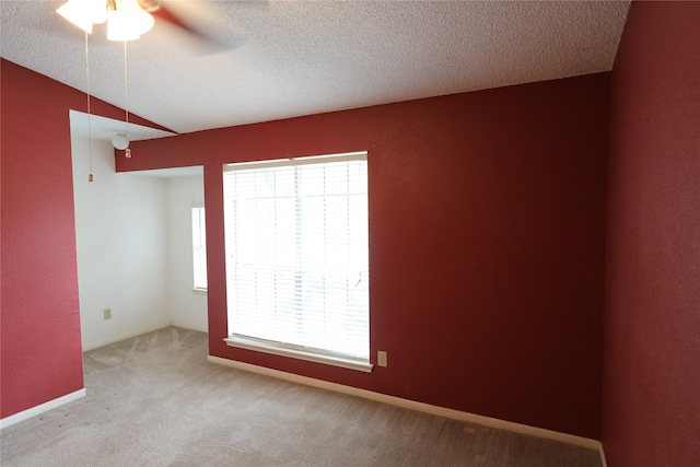 carpeted empty room featuring ceiling fan, a textured ceiling, and vaulted ceiling