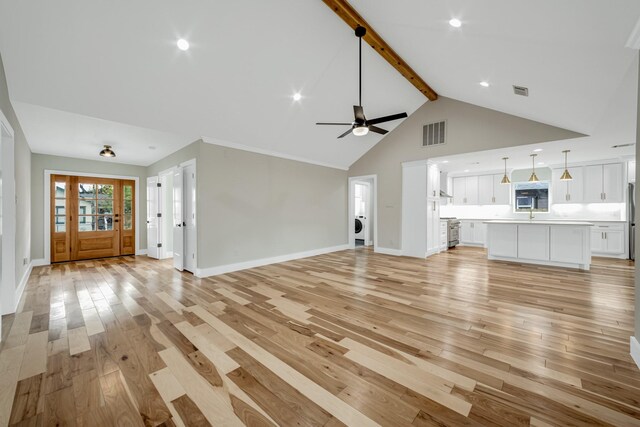 unfurnished living room featuring washer / clothes dryer, light hardwood / wood-style floors, beam ceiling, high vaulted ceiling, and ceiling fan