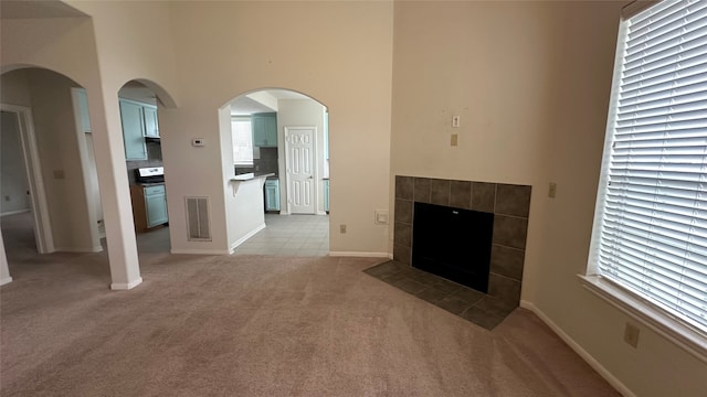 unfurnished living room featuring light colored carpet and a fireplace