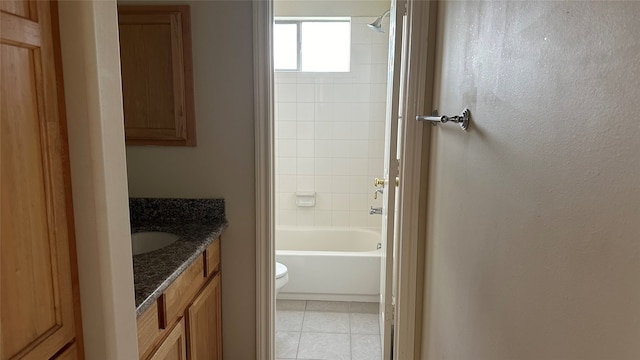 full bathroom featuring vanity, tiled shower / bath combo, and toilet