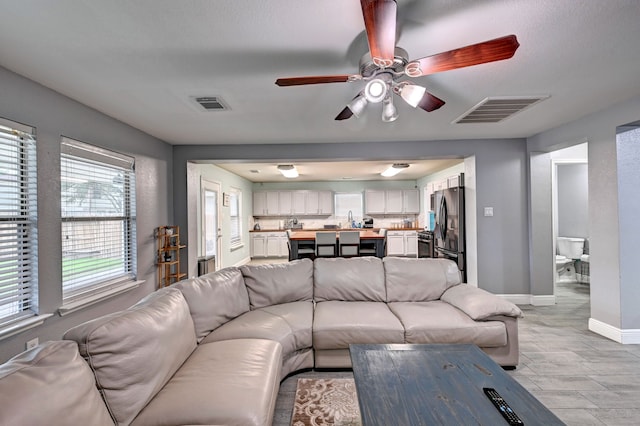 living room with sink and ceiling fan