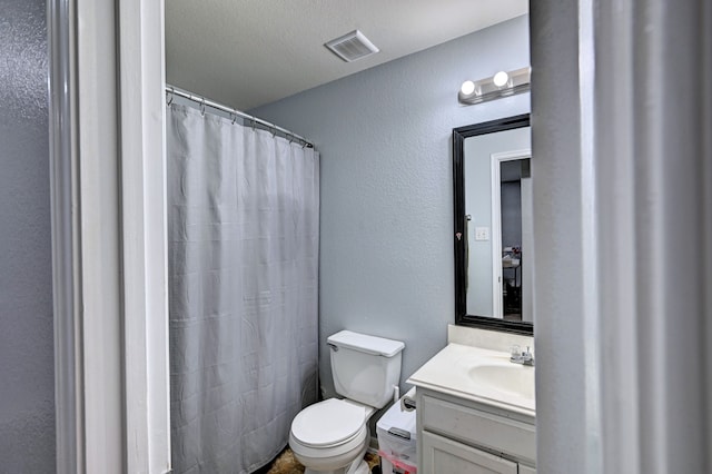 bathroom with a textured ceiling, vanity, toilet, and a shower with curtain