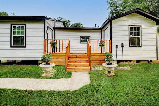 706 Beaumont St, Anahuac, TX 77514 - rear view of house featuring a yard and a wooden deck