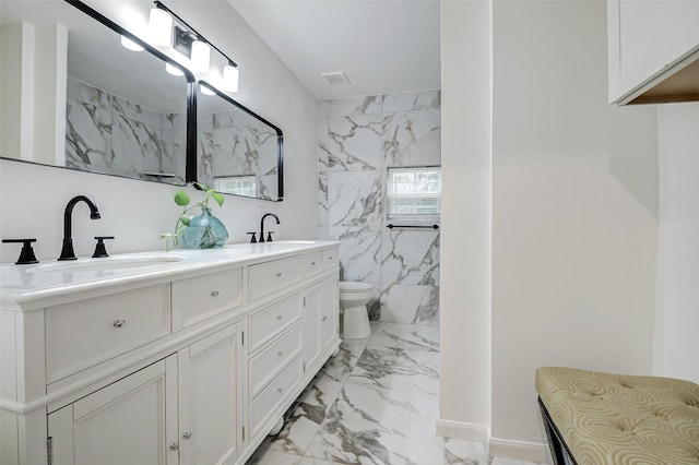 706 Beaumont St, Anahuac, TX 77514 - full bath with marble look tiles, double vanity, toilet, and a marble finish shower