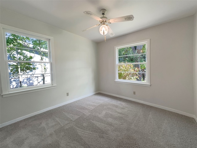 carpeted spare room with ceiling fan and a healthy amount of sunlight