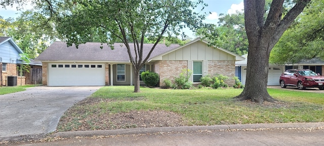 ranch-style house featuring a front lawn, central AC unit, and a garage