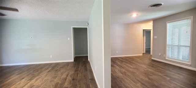 unfurnished room featuring a textured ceiling and dark hardwood / wood-style flooring