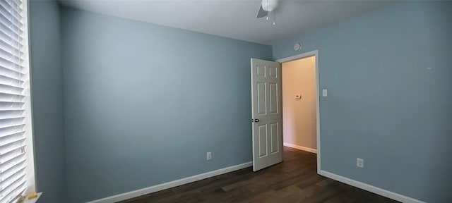 spare room featuring ceiling fan and dark wood-type flooring