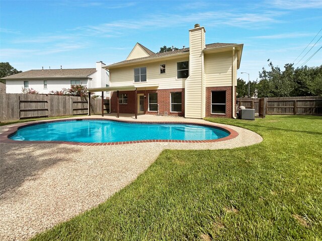 view of pool featuring a lawn, a patio area, and central AC unit