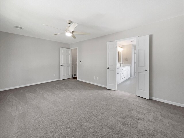 unfurnished bedroom with carpet, ensuite bathroom, and ceiling fan