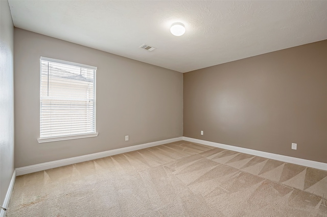 carpeted empty room featuring a textured ceiling