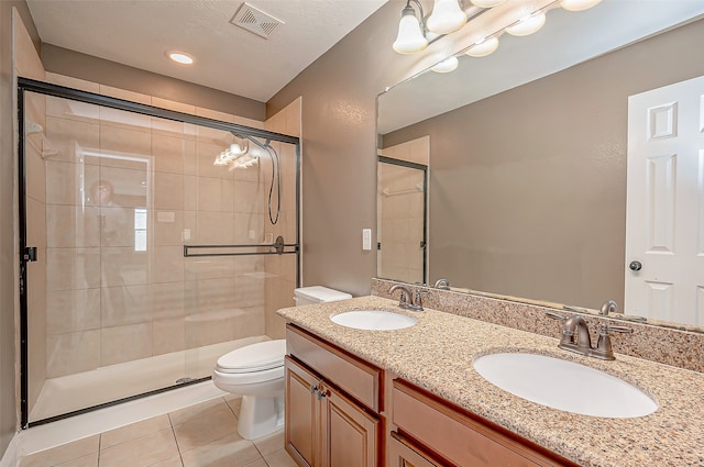 bathroom with tile patterned flooring, a shower with shower door, vanity, and toilet