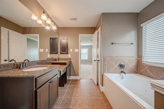 bathroom with vanity, tile patterned flooring, and a washtub