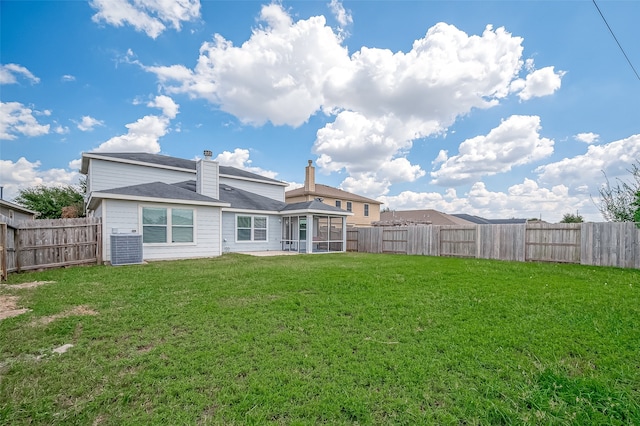 rear view of property featuring a lawn, cooling unit, and a sunroom