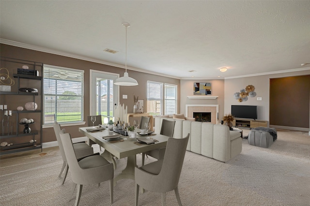 carpeted dining room with ornamental molding, a textured ceiling, and a fireplace