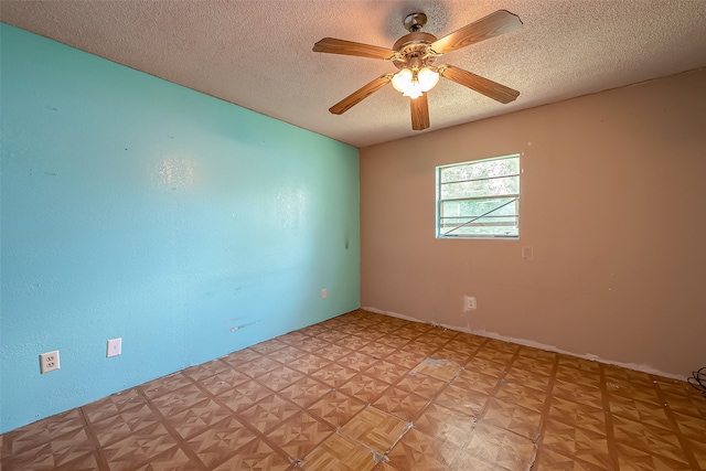 unfurnished room with ceiling fan and a textured ceiling