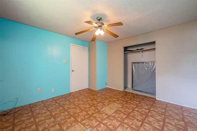 unfurnished room with ceiling fan, a textured ceiling, and light parquet floors