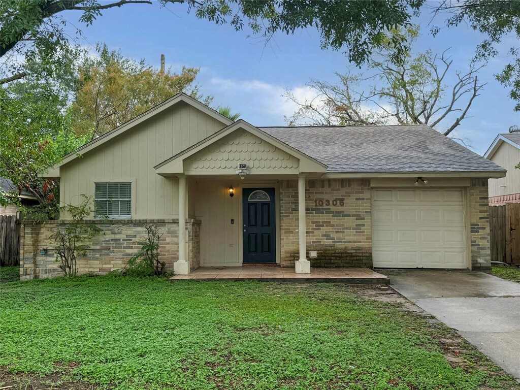 ranch-style home featuring a garage, a front lawn, and a porch