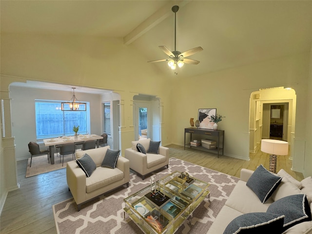 living room featuring ceiling fan with notable chandelier, beamed ceiling, light wood-type flooring, and decorative columns