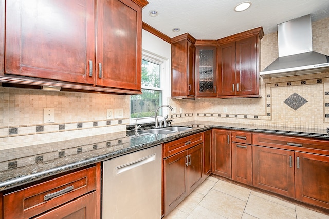 kitchen with dishwasher, tasteful backsplash, sink, wall chimney range hood, and dark stone countertops