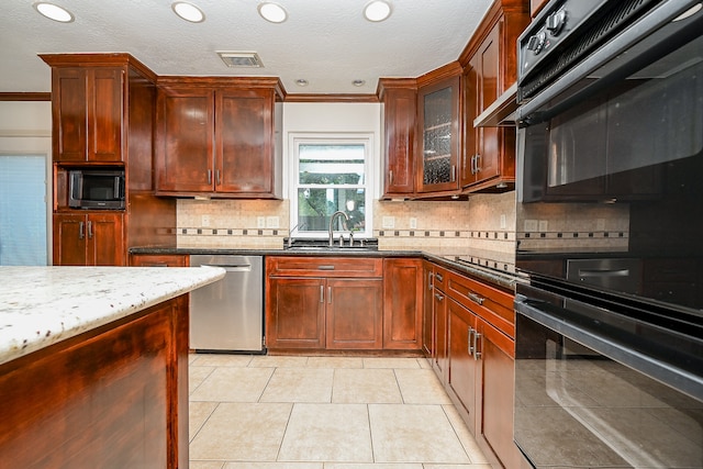 kitchen with light stone counters, stainless steel appliances, backsplash, light tile patterned floors, and ornamental molding