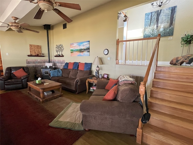 living room with ceiling fan, wood-type flooring, and a wood stove