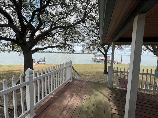 wooden deck with a lawn and a water view