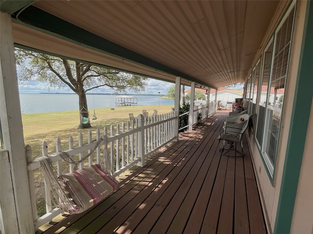 wooden terrace featuring a lawn and a water view