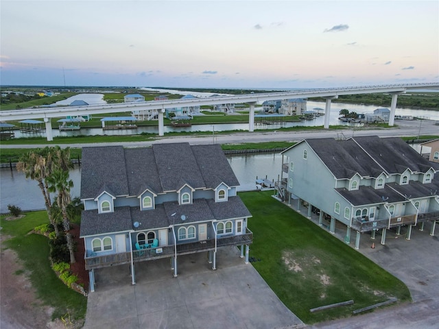 aerial view at dusk featuring a water view