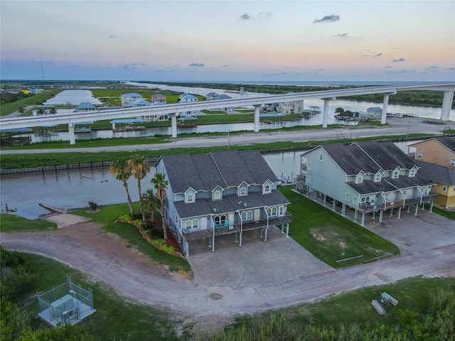 aerial view at dusk featuring a water view