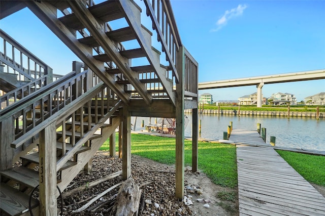 dock area featuring a lawn and a water view