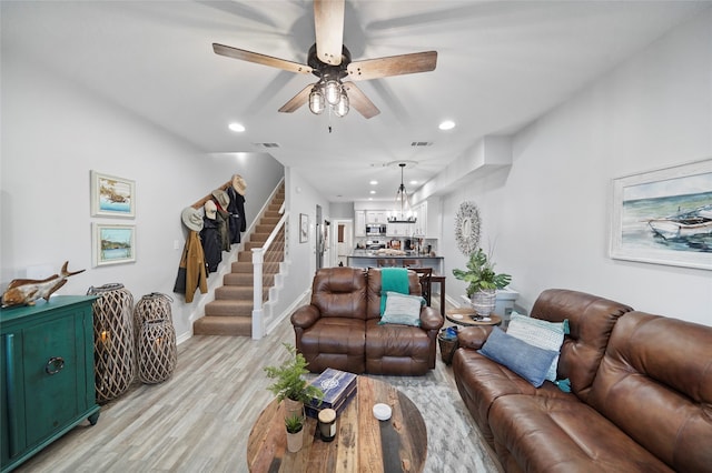 living room with ceiling fan and light hardwood / wood-style flooring