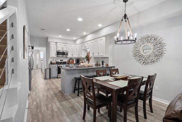 dining room with hardwood / wood-style flooring and a notable chandelier