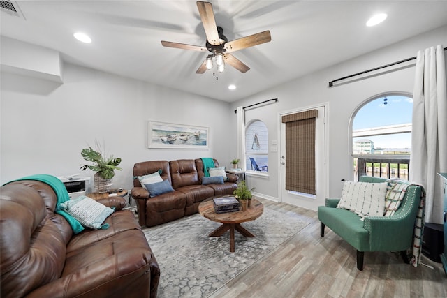 living room with ceiling fan and light hardwood / wood-style flooring