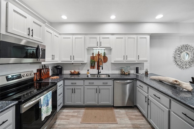 kitchen with light wood-type flooring, gray cabinetry, sink, and stainless steel appliances