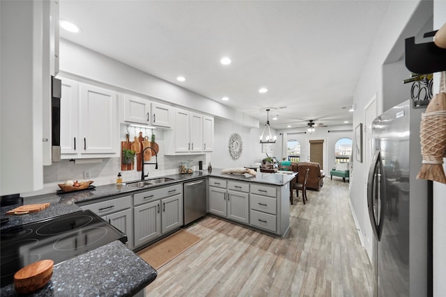 kitchen with appliances with stainless steel finishes, hanging light fixtures, gray cabinetry, kitchen peninsula, and sink